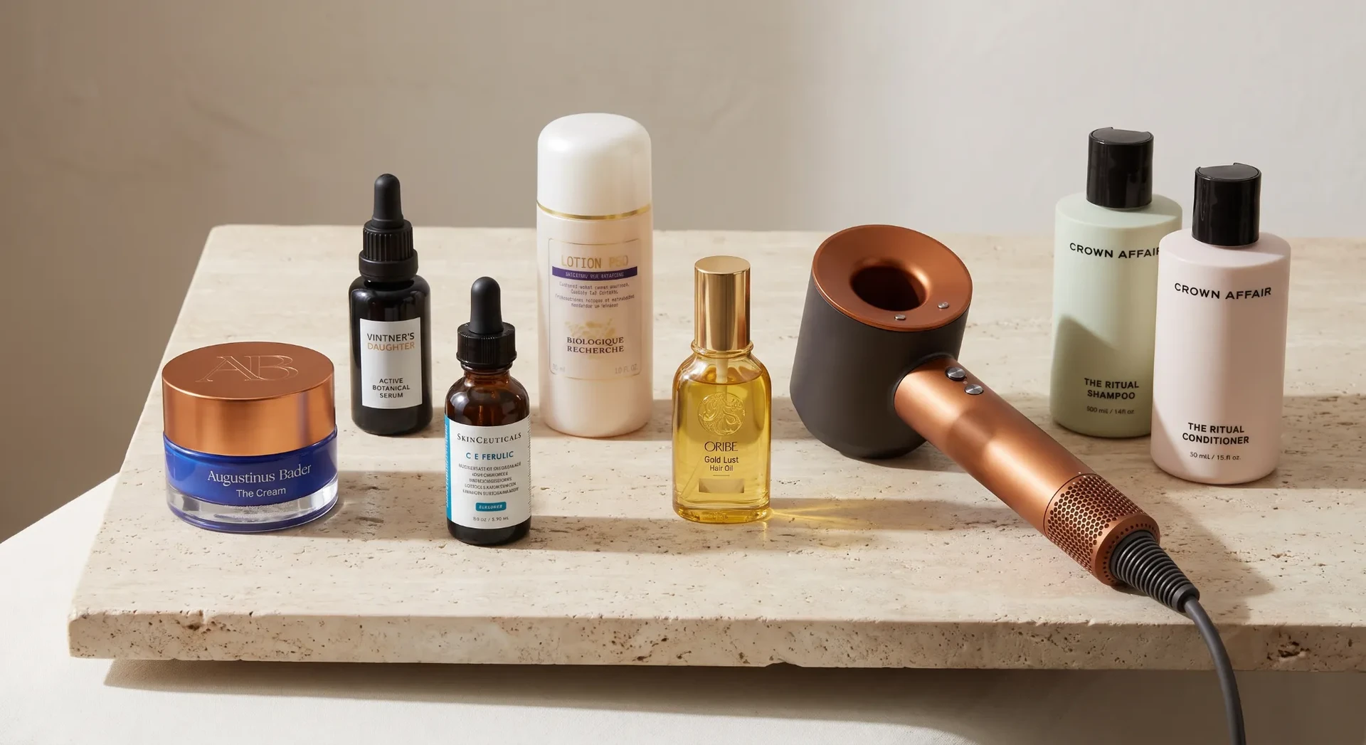 Skincare and hair products arranged with a styling tool