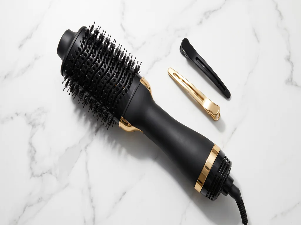 Hot air styling brush and professional hair products arranged on a modern beauty vanity
