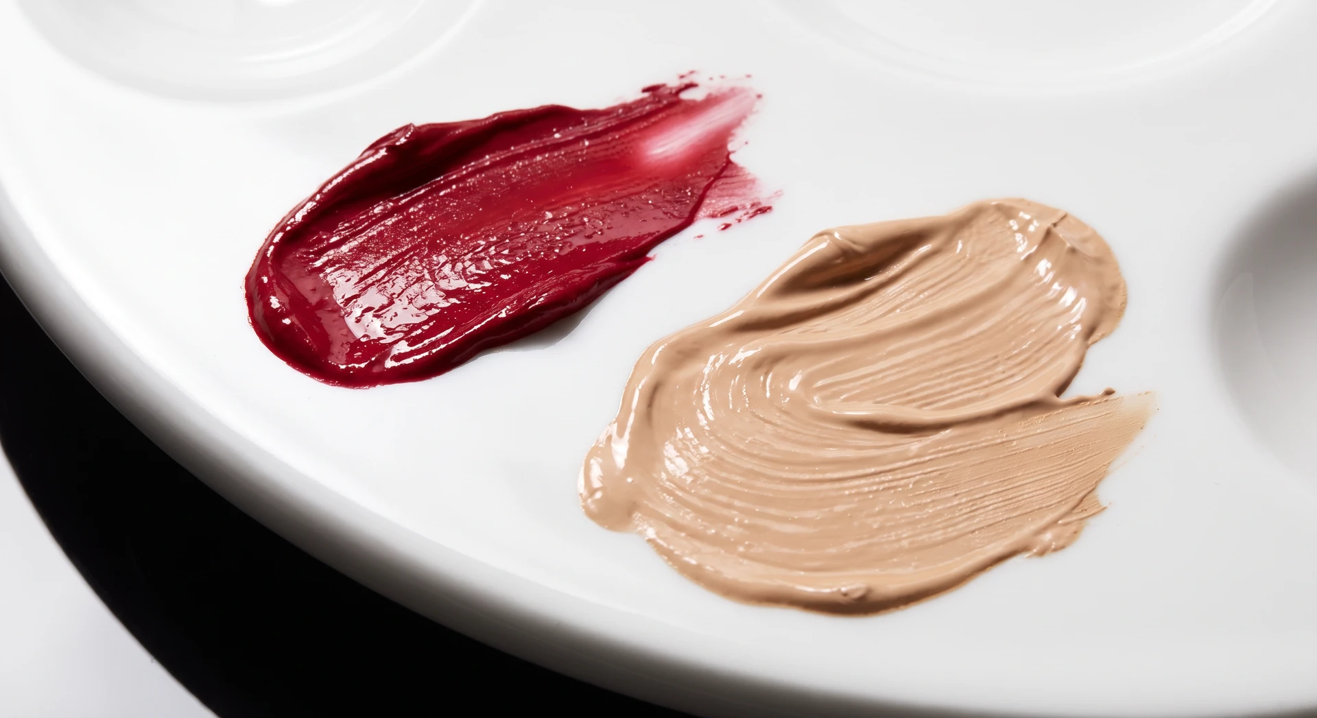 Berry lip colour and complexion swatches on a white palette