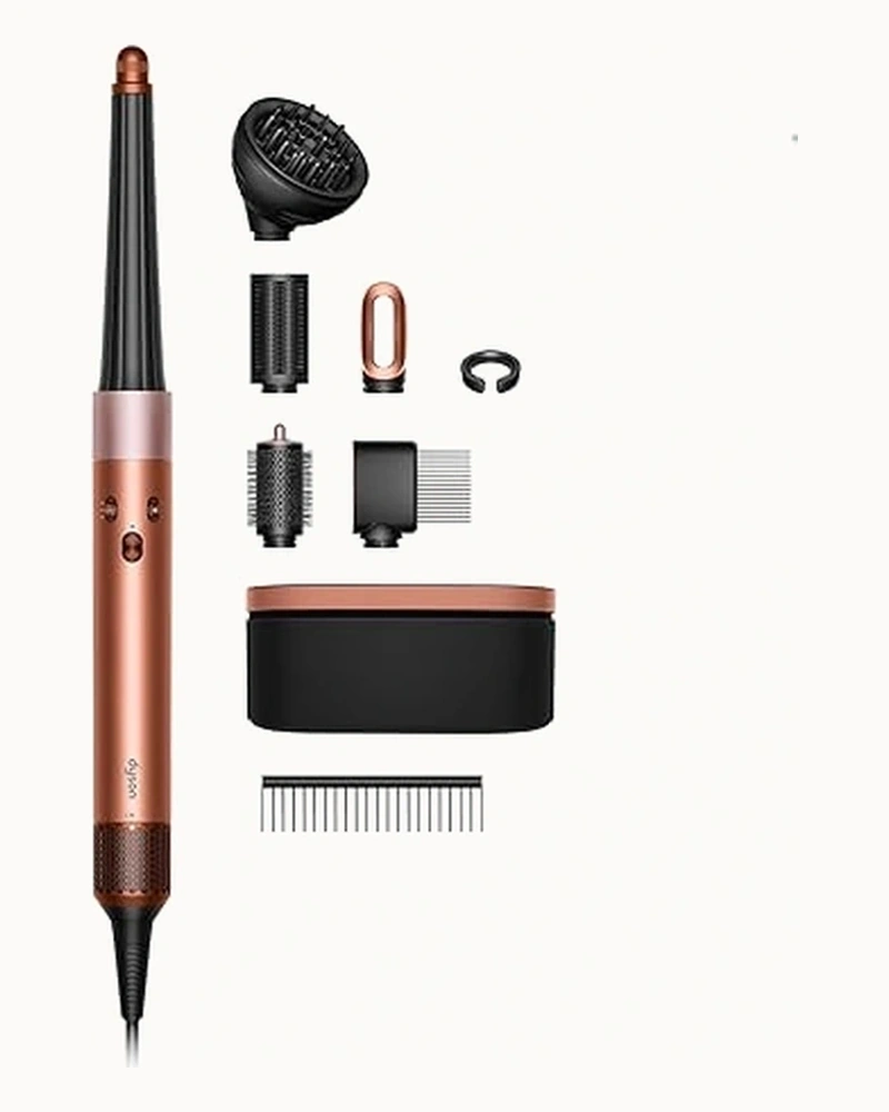 Dyson Airwrap Multi-Styler styling wand and attachments on warm studio surface