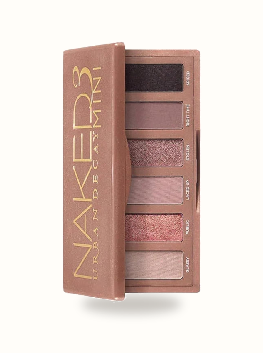 Urban Decay Naked3 Eyeshadow Palette open displaying rose-gold neutral eyeshadow pans on warm porcelain background